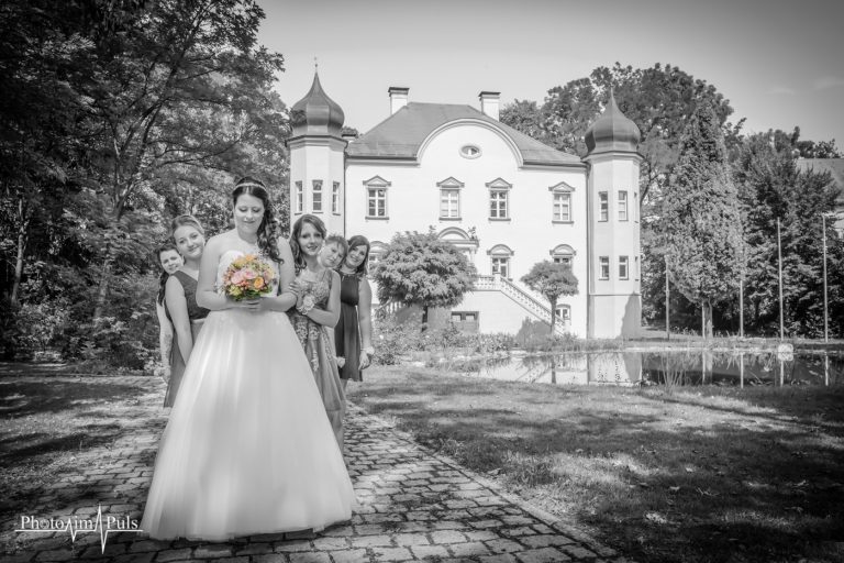 Schwarz-Weiß-Foto einer Braut mit Brautjungfern vor einem Schloss