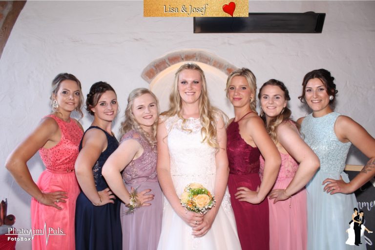 Braut mit Brautjungfern in bunten Kleidern vor der Fotobox