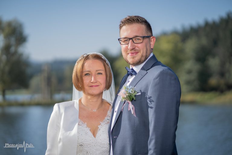 Brautpaar lächelt vor dem See