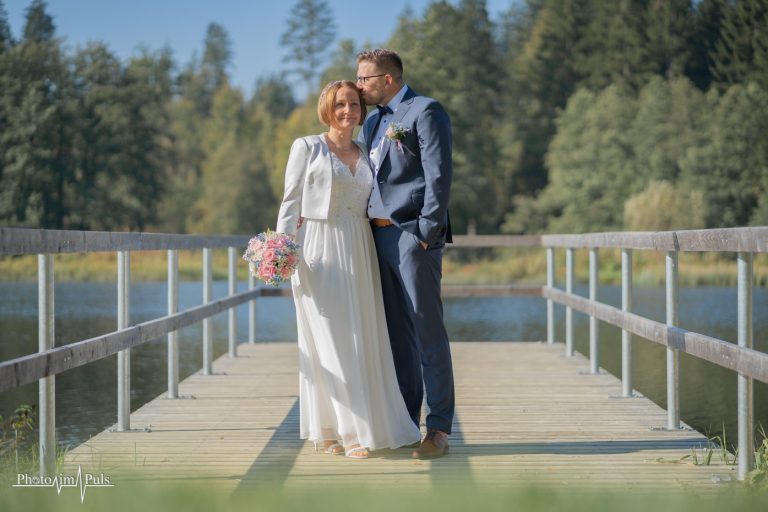 Marko küsst Charlotte auf dem Holzsteg